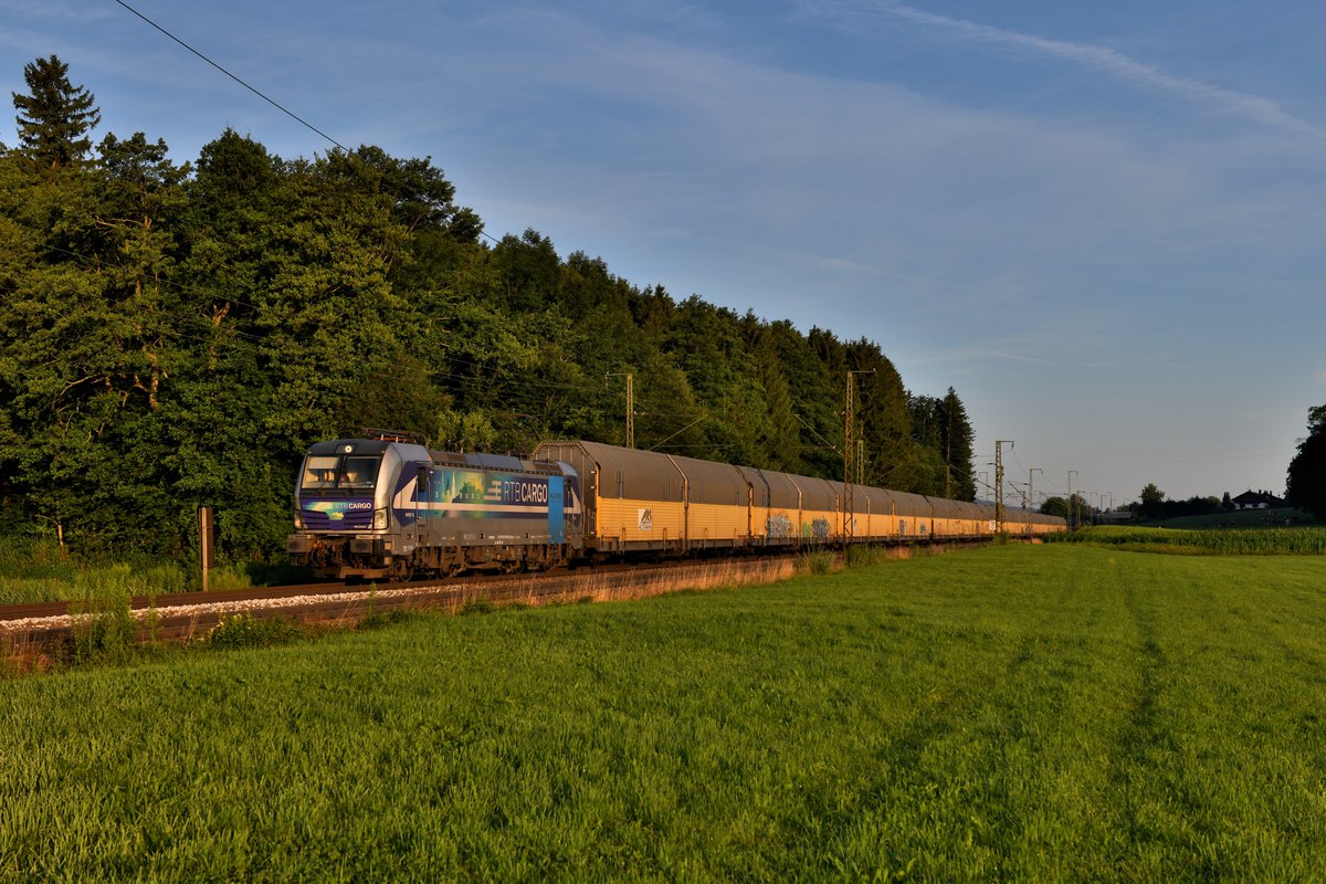Am 23. Juli 2019 widmete ich mich erneut den Umleitern auf der KBS 951, die aufgrund der Sperre der Passauerbahn den Weg über das Berchtesgadener Land und das Chiemgau nahmen. Kurz nach Sonnenaufgang konnte ich die 193 810 der Rurtalbahn mit dem leeren Autotranspportzug DGS 45985 von Bremerhaven nach Hegyeshalom bei Niederstraß aufnehmen. Durch die Umleitungsaktion kam die auf den Namen Salzburg getaufte Lok tatsächlich durch die entsprechende Region. Dies kommt planmäßig nicht vor. 