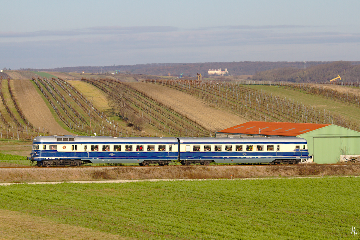 Am 23.11.2019 veranstaltete das Heizhaus Strasshof eine Abschiedsfahrt mit dem Triebwagen 5145.014 auf den zur Einstellung des Personenverkehrs vorgesehenen Strecken des Groß Schweinbarther Kreuzes.
Dieses Bild zeigt den Sonderzug kurz vor Auersthal. Im Hintergrund die Burg Matzen.