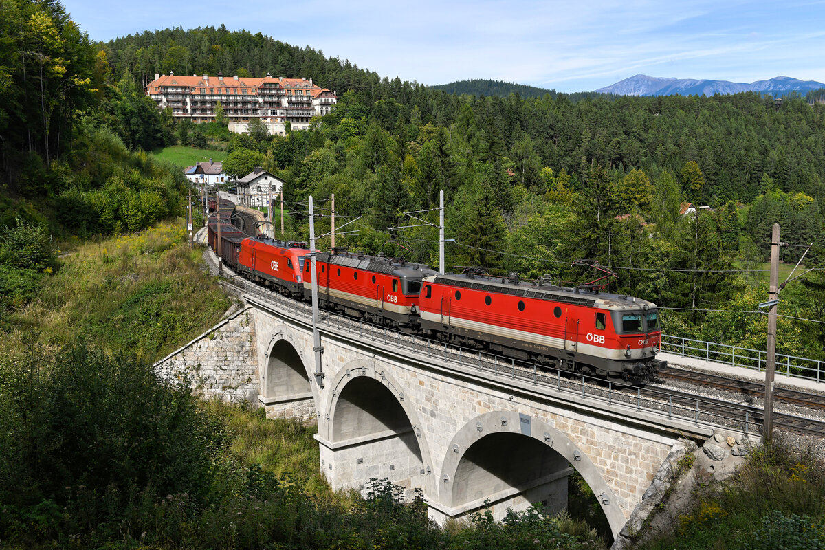 Am 24. September 2021 konnte ich die 1144.036 vor der 1144.258 und der 1116.060 als Dreifachtraktion vor einem mit Schrott beladenen Ganzzug bei der Durchfahrt der Station Wolfsbergkogel am Semmering aufnehmen. Im Hintergrund ist das Kurhaus Semmering zu sehen, rechts davon der Schneeberg. 