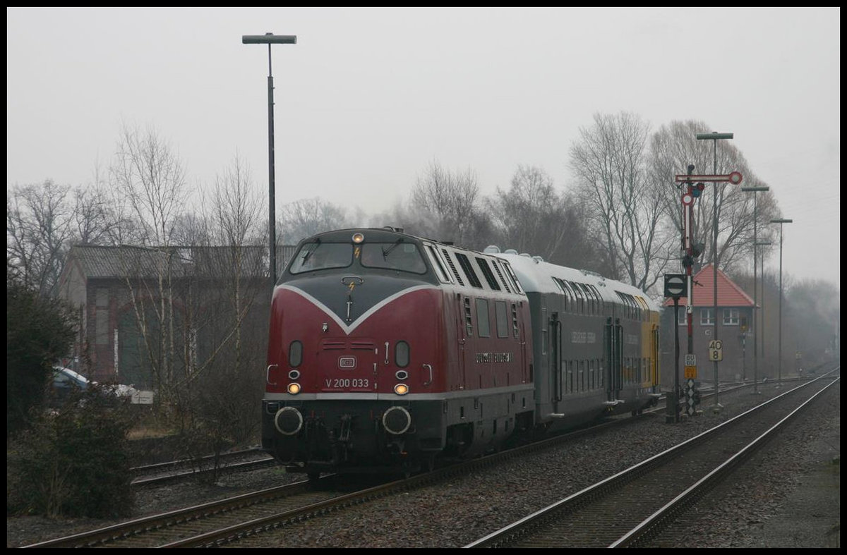 Am 24.2.2007 kam die Hammer V 200033 mit dem musealen Lübeck Büchener Doppelstockzug im Rahmen einer Sonderfahrt nach Cloppenburg. Hier bei der Anfahrt passiert sie an diesem regnerischen Tag morgens den im Hintergrund sichtbaren ehemaligen Lokschuppen.