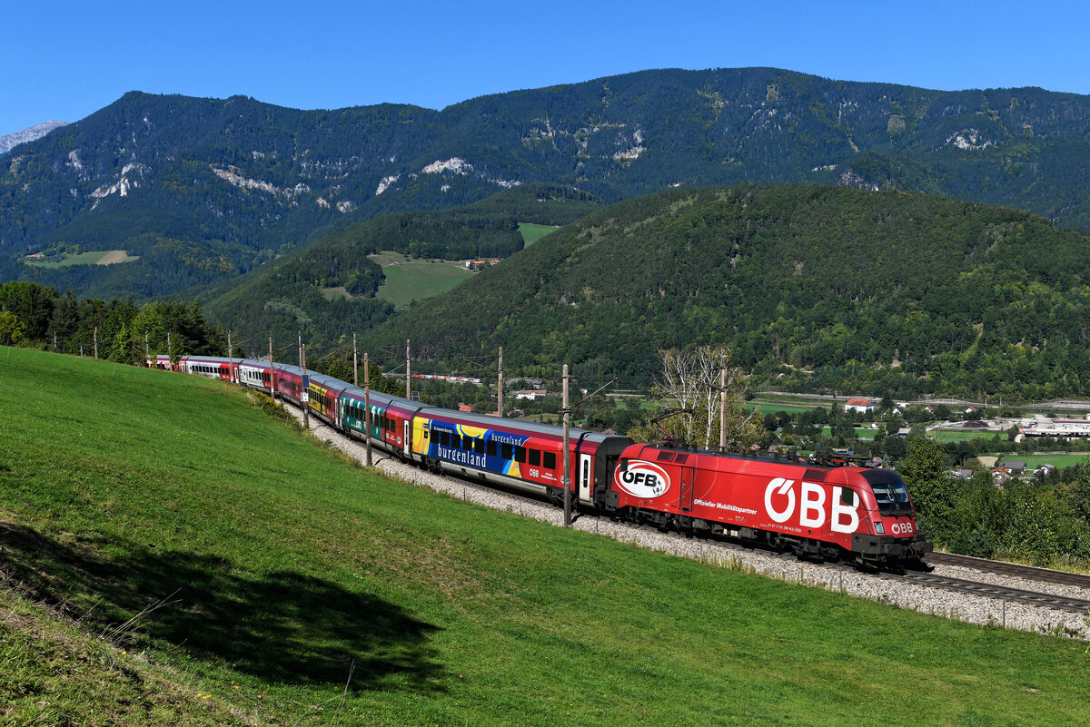 Am 25. September 2021 verkehrte der ÖFB-Railjet als RJ 653 von Flughafen Wien Bahnhof nach Graz HBF. Bei Eichberg am Semmering konnte ich die 1116.249 mit ihrem bunt gestalteten Zug aufnehmen. Unten im Tal kann man einen REX in Richtung Wiener-Neustadt fahrend erkennen.