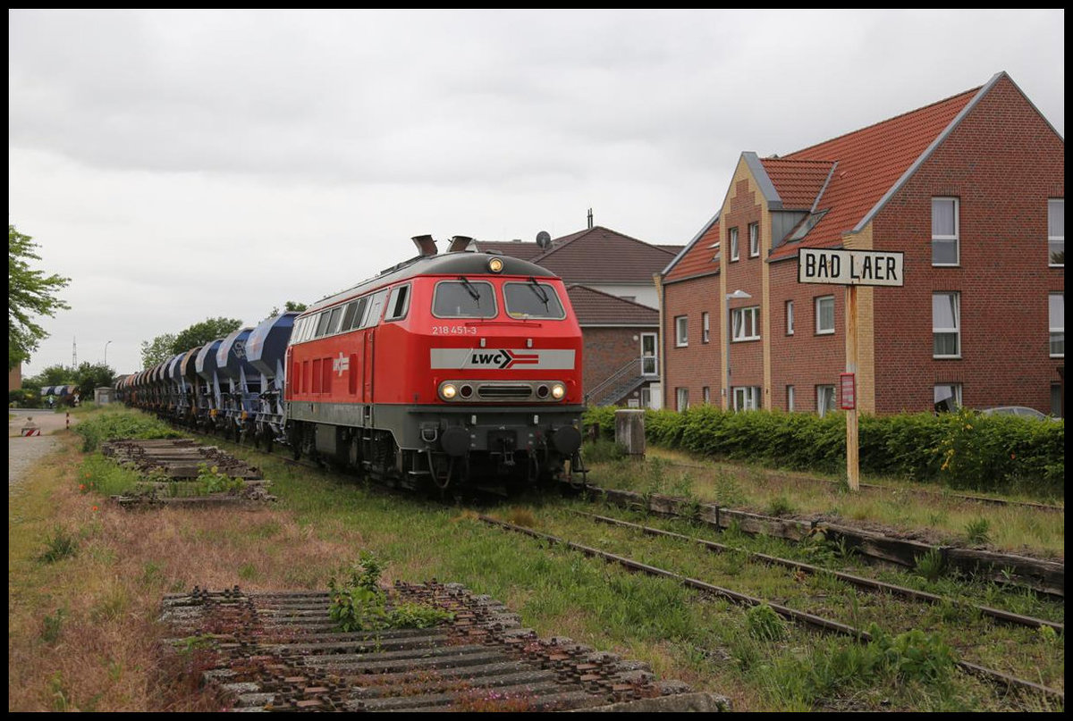 Am 25.05.2020 kam die 218451-3 der LWC mit einem Schotterzug von Gütersloh aus auf die Strecke der Teutoburger Wald Eisenbahn, um dort bei der Restauration der Strecke weiter Schienenbereiche ein zu schottern. Nach der Entladung fuhr der Zug weiter nach Lengerich, um von dort aus über die Rollbahn weiter nach Münster zu fahren. Hier erreicht der Zug gerade den früheren Bahnhof von Bad Laer. Das Ortszeichen steht noch immer auf dem alten Bahnsteig Bereich.