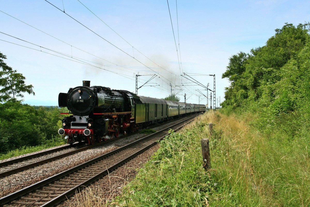 Am 26.06.15 war die Starlok des DB-Museums, die 01 150, mit dem DPE 13481 von Frankfurt S�d nach Luzern unterwegs. Der in der Schweiz als SDZ 31191 verkehrende Zug bekam ab Basel Vorspann durch die ehemalige SNCF-Schnellzugdampflok 141R 1244, welche ihn mit der 01 150 zusammen bis an sein Ziel brachte. Auch die 01 202, die seit 1975 in der Schweiz zu Hause ist, sollte sp�ter noch eine Rolle spielen.

Auf dem Bild ist das traumhafte Gespann auf der alten Rheintalbahn zwischen Schliengen und Haltingen s�dlich von Rheinweiler aufgenommen worden.