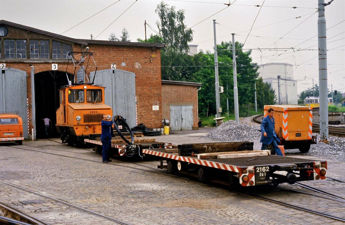 Am 26.07.1984 hatte Ellok 2023 (SSB) mit Wagen 2161 und 2162 (SSB) vor dem Straßenbahndepot Möhringen (früher Filderbahn) einen Zug für ca. 30 Minuten für Gleisbauarbeiten neben der Linie 3, welche hier rechts vorbeifährt, geladen.