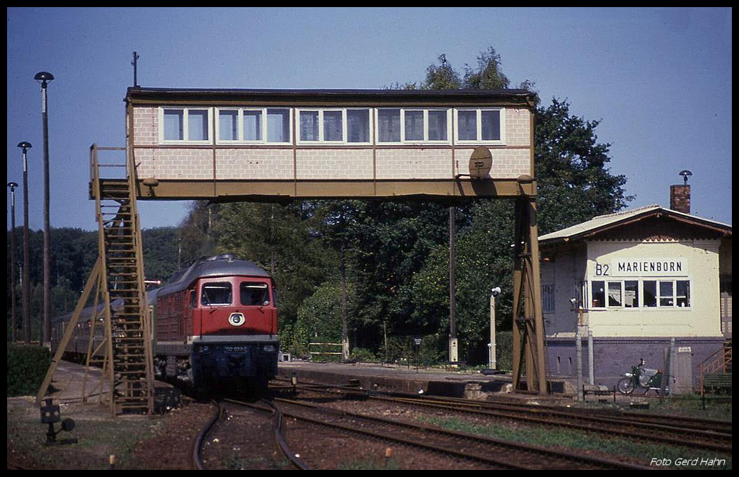 Am 26.08.1990 stand noch die alte Infrastruktur der DDR Grenzsicherung im Bahnhof Marienborn, als dort der D aus Aachen mit der 132033 einfuhr. Die Posten Brücke war das bekannte und markante Zeichen für den damaligen Grenzbahnhof Marienborn.