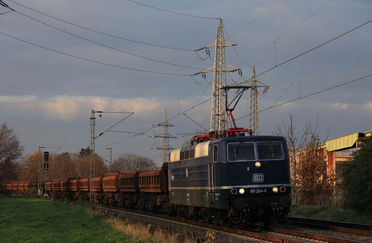 Am 26.11.2020 zog SEL 181 204`Rügen´ im letzten Abendlicht einen Altschotterzug von der Baustelle zwischen Immigrath und Opladen-Mitte von Düsseldorf-Eller nach Stolberg(Rheinl) Gbf durch Dormagen Chempark. 
