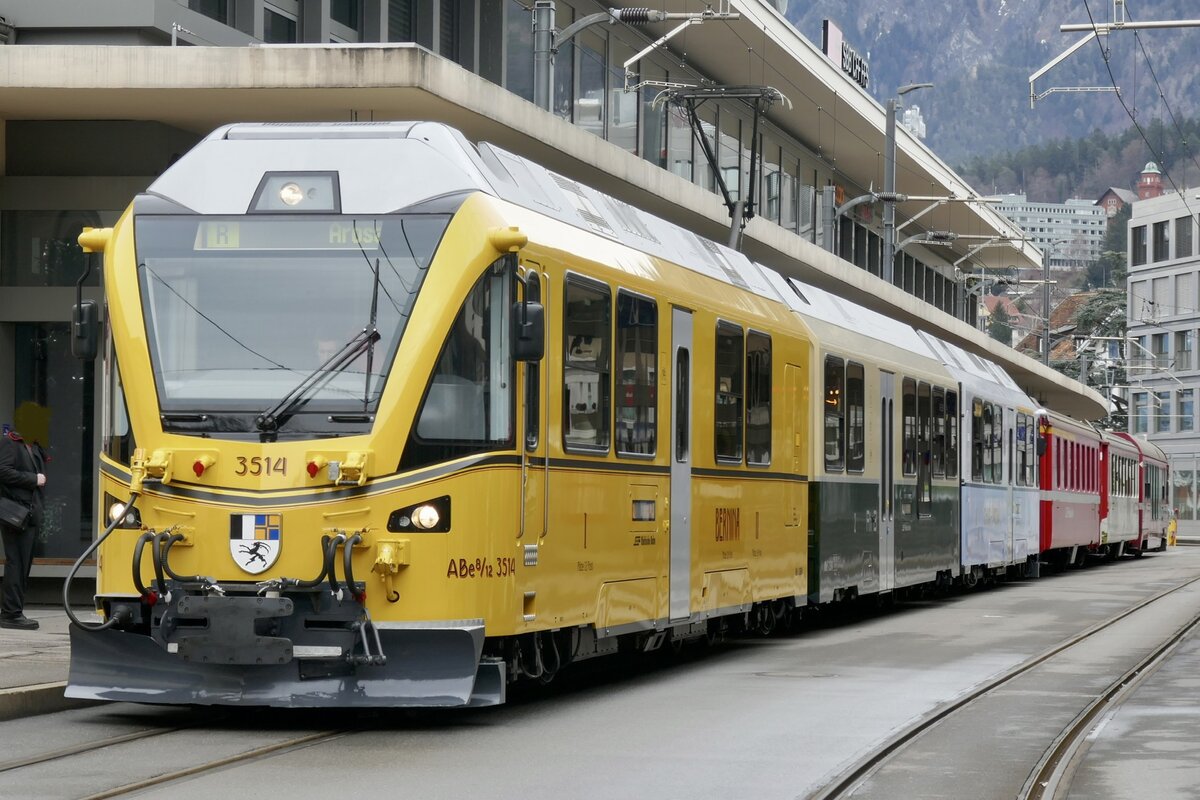 Am 26.12.23 wartet der  Ahnenzug  ABe 8/12 3514 mit seinen Arosapendel auf dem Bahnhofplatz Chur auf die Abfahrt nach Arosa.