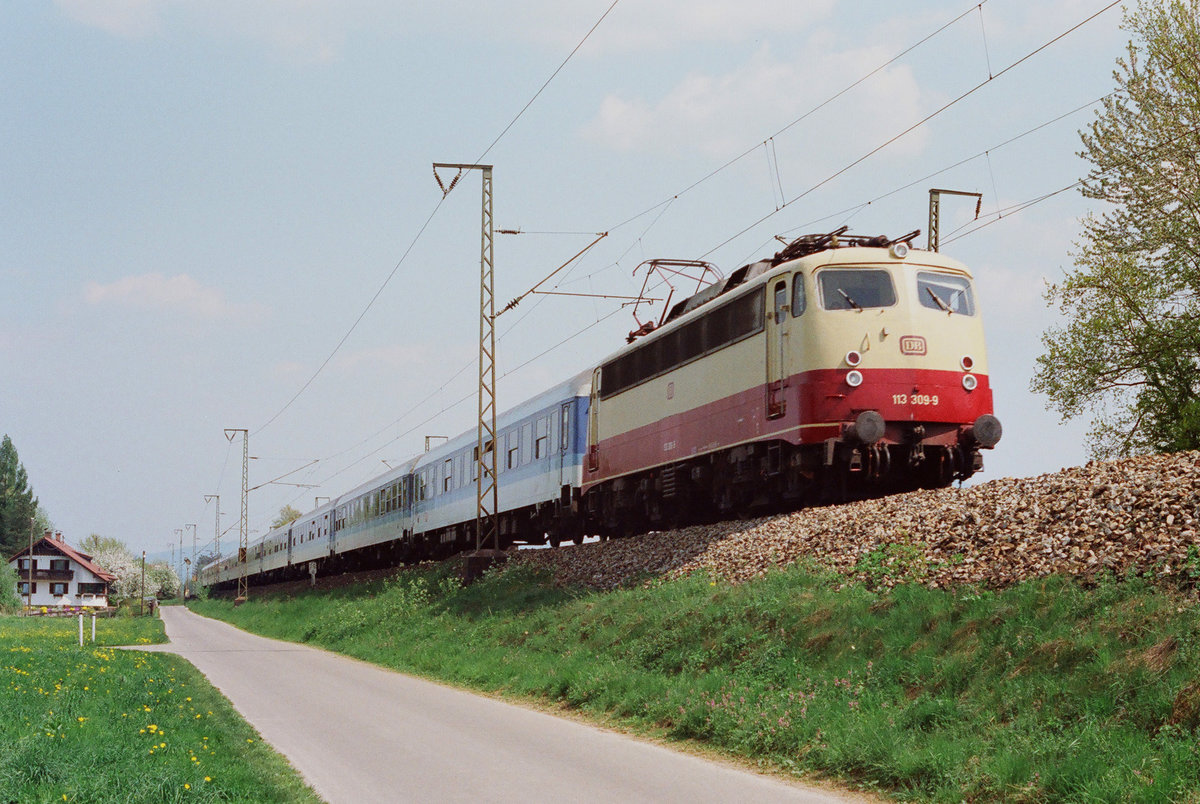 Am 28. April 1993 fährt Lok 113 309 auf der Strecke Freilassing - Traunstein bei Niederstraß mit einem IR nach München.