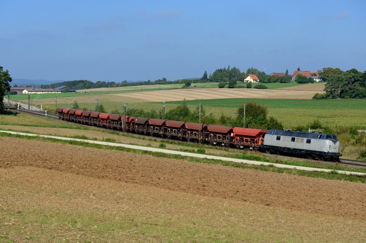 Am 28. September 2013 wurde unter dem laufenden Betrieb auf der KBS 880 auch geschottert. Zwischen Regensburg und Parsberg hatte sich der Bauzug seiner Fracht entledigt und befindet sich hier bei Sinngrün bereits auf der Rückfahrt. Zuglok ist die V 270.09 der SGL (Schienen-Güter-Logistik, Dachau). Die Lok hat eine bewegte Geschichte hinter sich: 1964 bei Krauss Maffei gebaut, war sie als 221 121 bei der DB im Einsatz, danach für die OSE in Griechenland. Von dort wurde sie vor einigen Jahren wieder nach Deutschland rücküberführt und aufgearbeitet. Nach Zwischenstationen bei der PEG und Arriva wird sie von SGL im Bauzugdienst deutschlandweit eingesetzt.
 