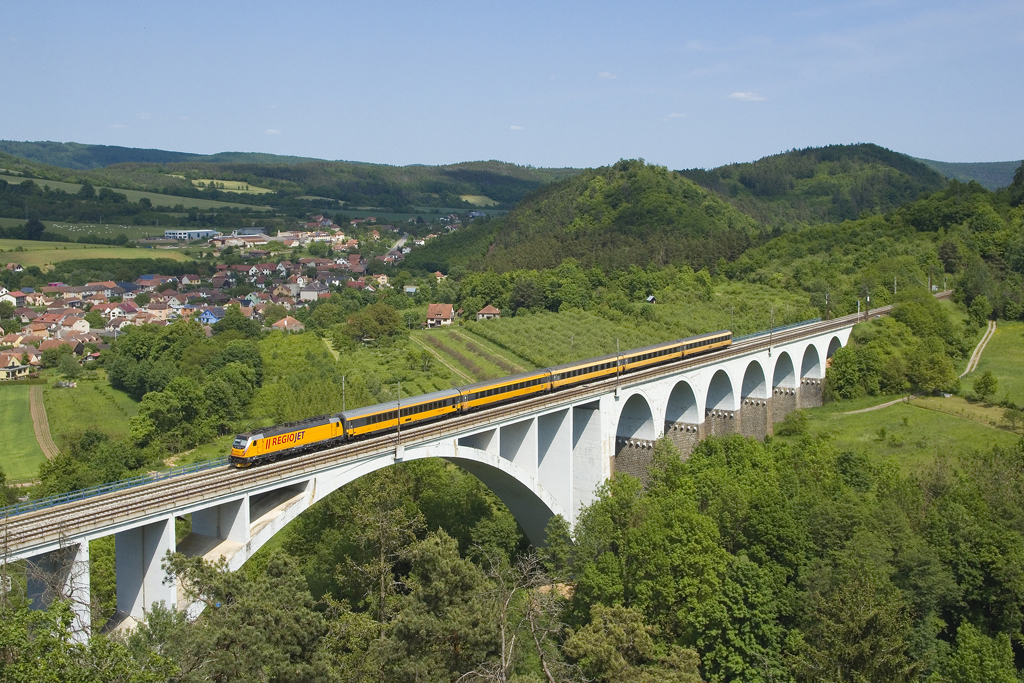 Am 29. Mai 2023 ist eine unbekannt gebliebene 388 mit dem RJ 1048 von Bratislava hl. st. nach Praha hl. n. unterwegs. Soeben befährt der gelbe Zug die Most míru bei Dolní Loučky.