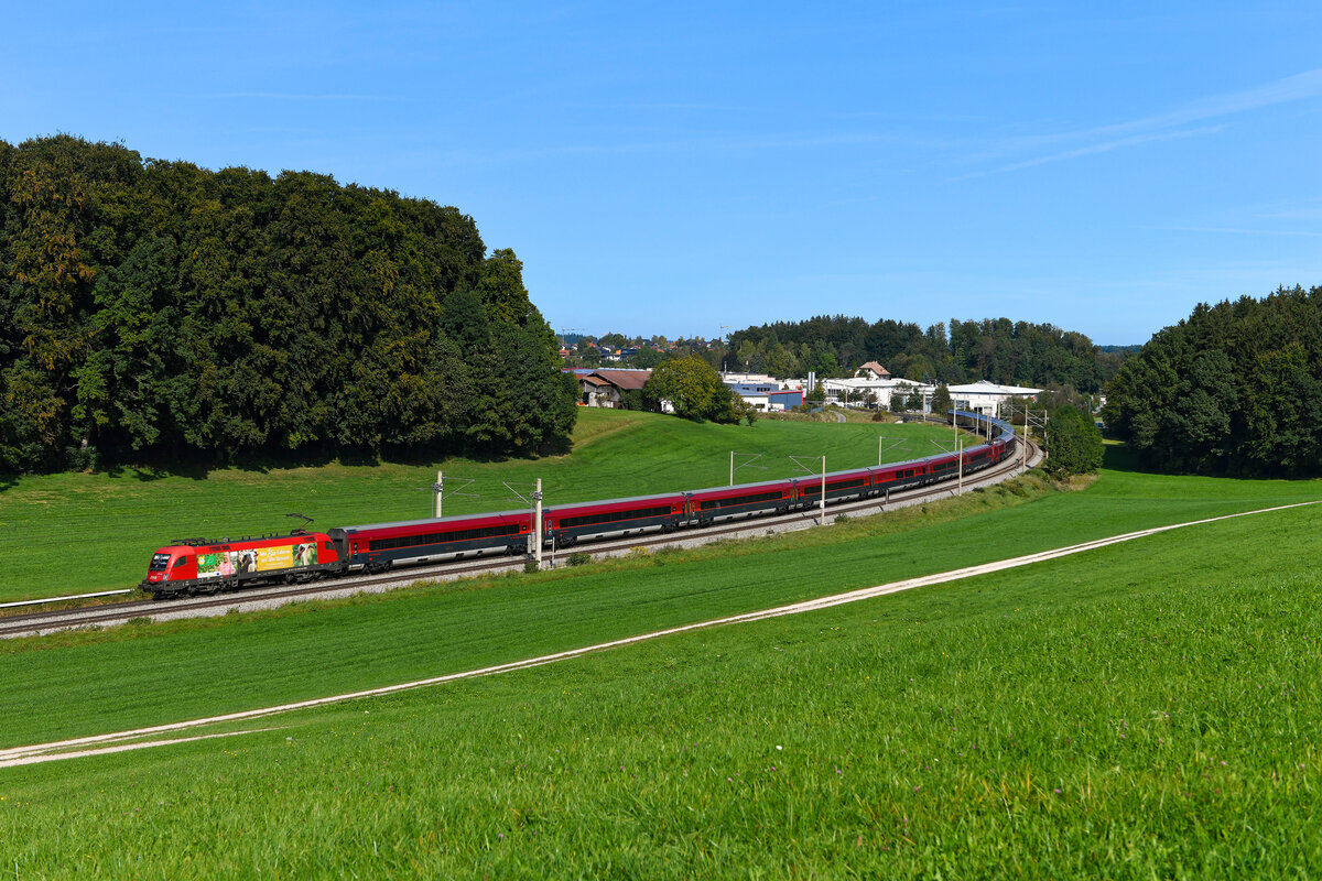 Am 29. September 2023 konnte ich den RJX 766 auf seiner Fahrt von Flughafen Wien nach Innsbruck HBF bei Axdorf im Chiemgau fotografieren. Geführt wurde der Railjet von der 1116.165, die für die biologische Landwirtschaft in Niederösterreich und Wien und somit für Klima- und Umweltschutz wirbt. Normalerweise ist dieser Taurus aufgrund des regionalen Bezuges der Werbung auch primär im Regionalverkehr rund um die österreichische Landeshauptstadt anzutreffen. Im Herbst 2023 kam die Lok jedoch für einige Wochen vor Railjets im Hochgeschwindigkeitsverkehr zum Einsatz. 