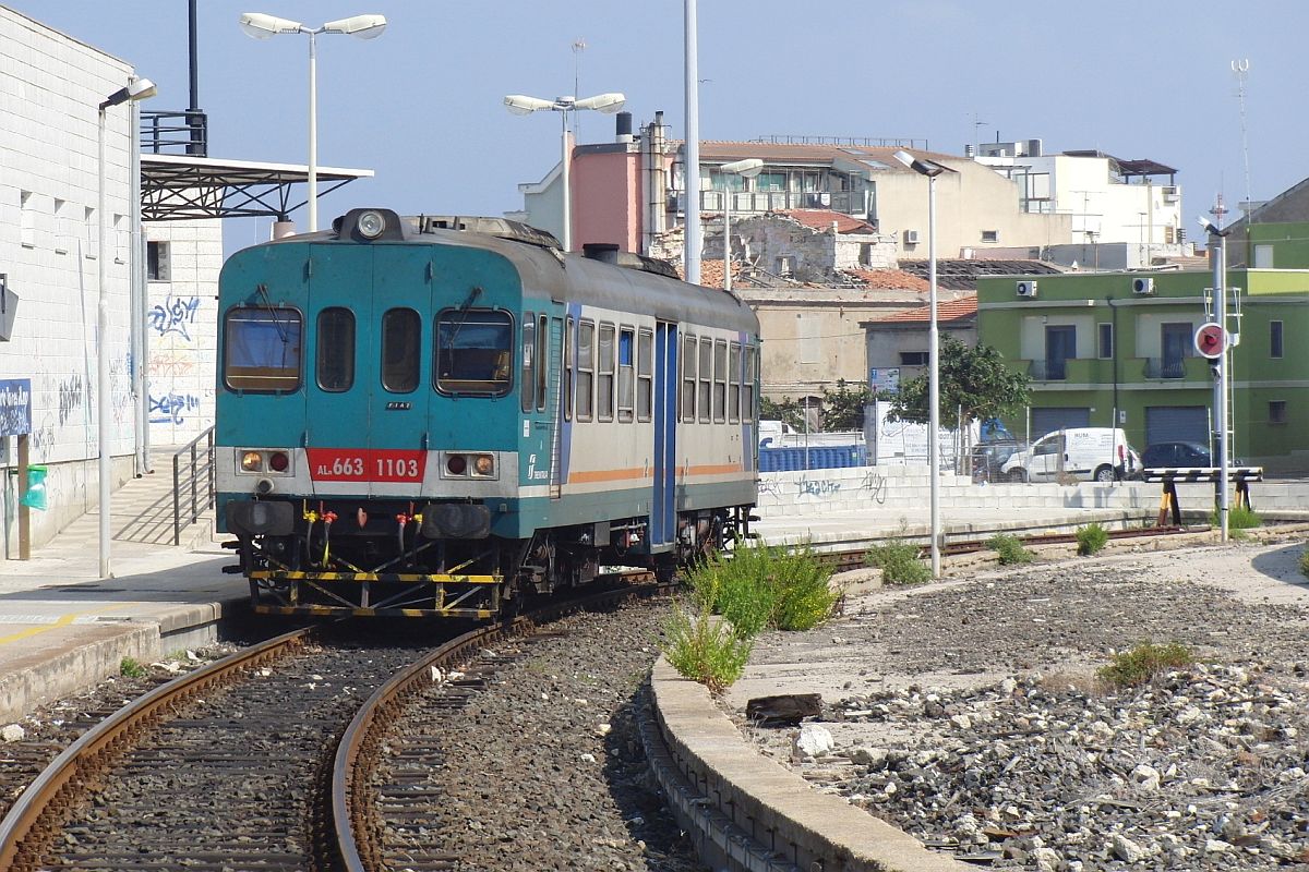 Am 29.09.2011 steht in der Station von Porto Torres Marittima der ALn 663 1103 bereit zur Abfahrt als Regionalzug 8903 nach Sassari. Fotostandpunkt fr diese Aufnahme mit Zoom ist auf dem Bahnsteig, der entsprechend der Lage des Gleises von einem Bahnsteigende bis zum anderen Ende einen greren Bogen beschreibt.