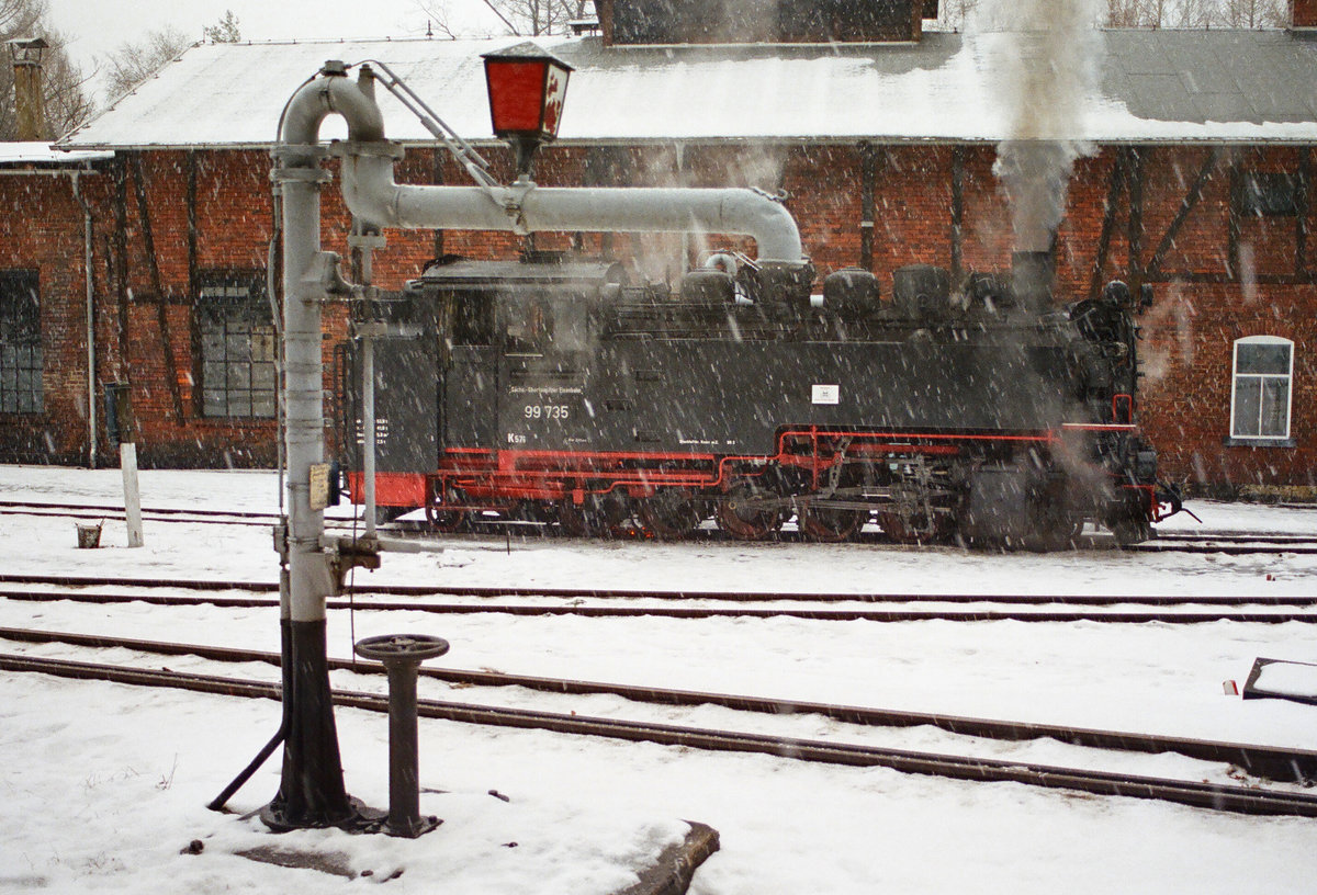 Am 30. Dezember 2002 verschnauft Lok DR 99 735 im Bahnhof Bertsdorf vor dem Lokschuppen.