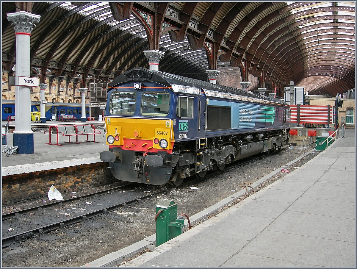 Am 30. März 2006 steht die gut gepflegte Diesellok 66407 abgestellt in York. Besonders gefällig: die dem Kurvenbereich angepassten Bahnsteighallen von York. 
