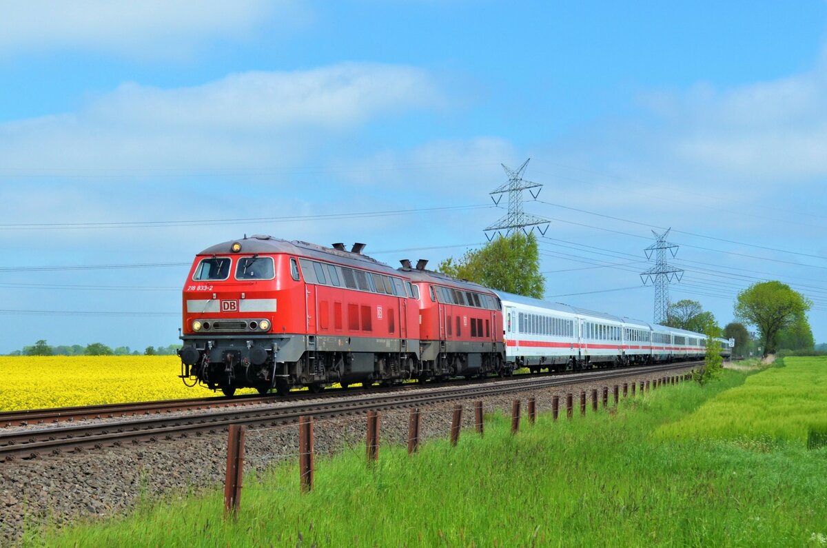 Am 30.05.21 zogen 218 833-2 und 218 385-3 den IC 2311 von Westerland (Sylt) nach Itzehoe, dort übernimmt eine 101 den Zug und bringt ihn bis nach Stuttgart weiter. Hier zu sehen kurz vor dem BÜ Hove in Wilster.
