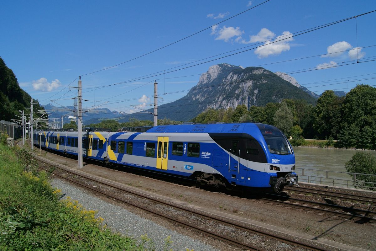 Am 30.07.2017 nähert sich ET320 des Meridian als M 79073 auf dem Weg von München Hbf. nach Kufstein dem Zielbahnhof. Im Hintergrund ist der Inn und der Zahme Kaiser zu sehen.