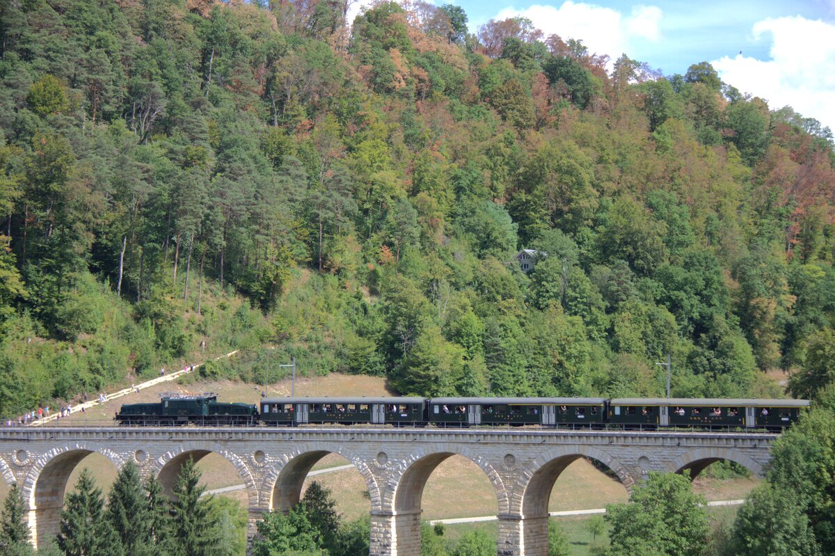 Am 30.08.2026 f�hrte SBB Historic wieder mal eine Fahrt mit dem Schr�gstangenkrokodil durch, hier in Richtung Sissach auf dem R�mlingerviadukt. Die Stelle ist ein Klassiker f�r Eisenbahnfotografen.
Die Einheitswagen wurden nur selten von einem Krokodil gezogen, es kam aber vor. was f�r einen realistischen Zug fehlt, ist ein Gep�ckwagen.