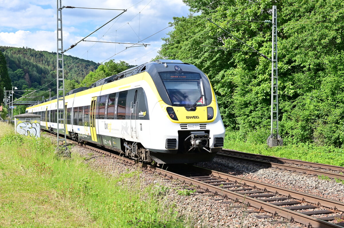 Am 30.5.2022 kam der SWEG umgezeichnete Triebwagen 8442 311 durch Neckargerach mit Sonderzug im Zielanzeiger gen Binau gefahren, ich vermute mal das es sich um eine Überführungsfahrt gehandelt hatte, da er eigentlich in der Planzeit einer S1 unterwegs war, die aber reichlich zehn Minuten verspätet unterwegs gewesen ist.
Leider war mir nicht die Unschärfe auf der Lokfront aufgefallen, bei ausreichender Vergrößerung habe ich  Blindfisch  es dann auch erkannt.....also zeige ich es hier mal wieder als schlechtes Beispiel.;-)