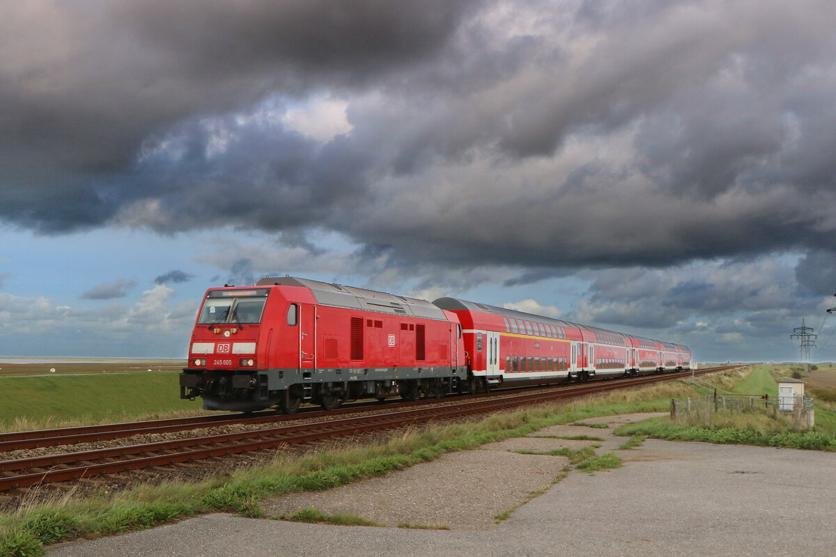 Am 30.9.2023 zogen dunkle Wolken über den echten Norden, davon unbeirrt zog 245 005 den einzigen Doppelstockpark auf der Marschbahn. Seine Fahrt führte den Zug ab Husum den nördlichen Teil der Marschbahn hinauf bis auf die Insel Sylt. Bei den Wagen handelt es sich zum Großteil um ehemalige Doppelstockwagen aus dem Bestand von DB Regio NRW.
