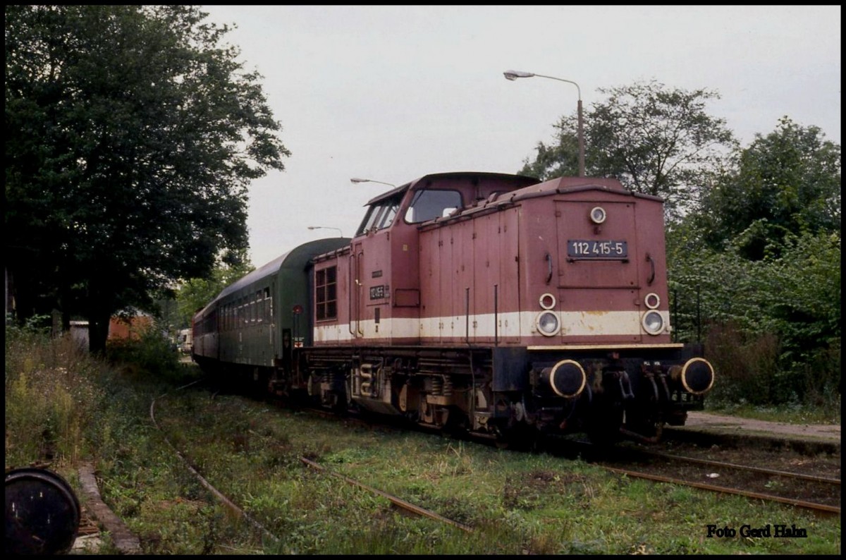 Am 3.10.1991 gab es noch Personenzugverkehr zwischen Rövershagen und Graal-Müritz auf der KBS 950. Bei einem kurzen Stopp auf der Fahrt nach Rügen erwischte ich 112415 mit dem P nach Graal Müritz auf einem Seitengleis des Bahnhofs. Fast hätte ich den Zug, der im  Sandwich  gefahren wurde, übersehen. 
