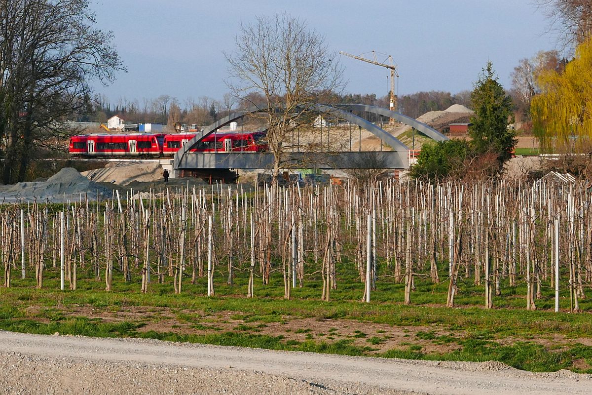 Am 31.03.2019 berquert RB 22788 von Friedrichshafen nach Radolfzell bei Fischbach die wenige Tage zuvor eingeschobene neue Eisenbahnbrcke, die ber eine im Bau befindliche vierspurige Umgehungsstrae fhrt.