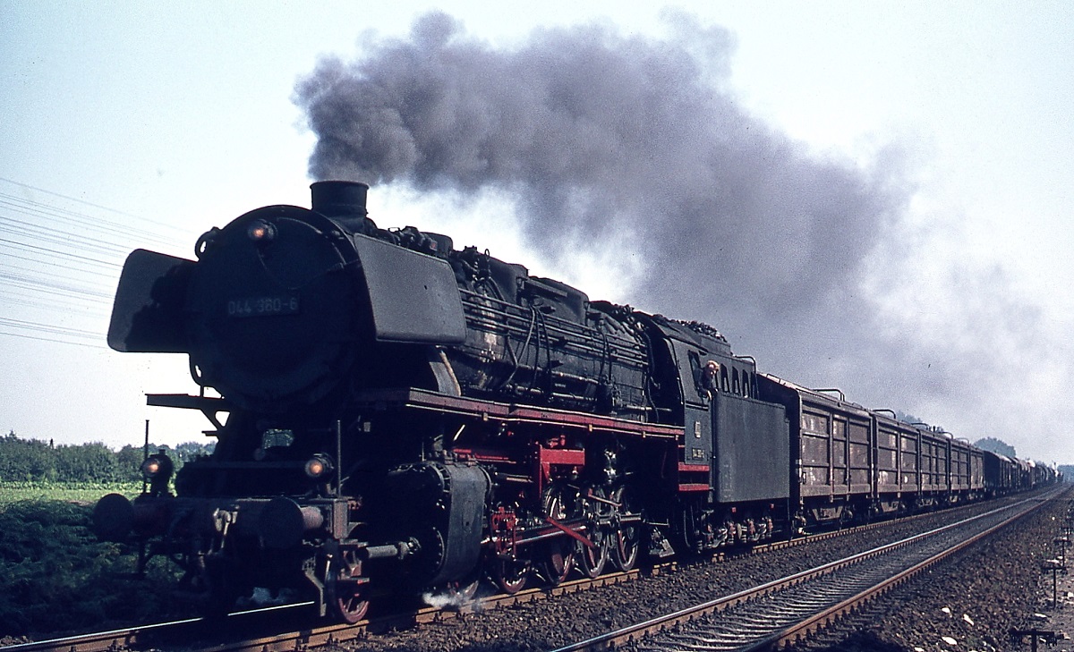 Am 31.08.1974 hat 044 380-6 mit einem Güterzug gerade Rheine verlassen und sich auf den Weg nach Emden gemacht. Neben den in den Bahnbetriebswerken Rheine und Emden beheimateten ölgefeuerten 043 waren auch die Emdener Kohle-044 noch recht häufig vor Güterzügen anzutreffen, während die Rheiner 042 neben Güterzügen auch Eilzüge beförderten.