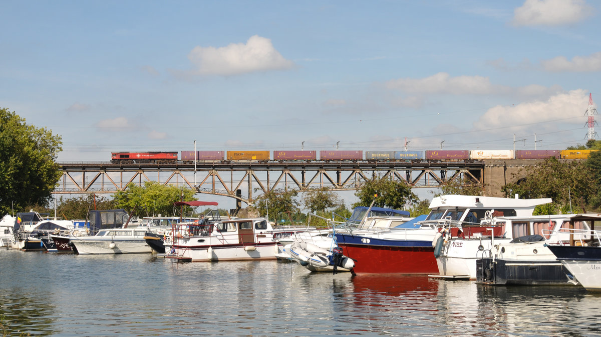 Am 3/9/2016 überquerte eine rote Class66 von Crossrail mit einem Containerzug am Haken die Maasbrücke in Visé gen Hasselt.