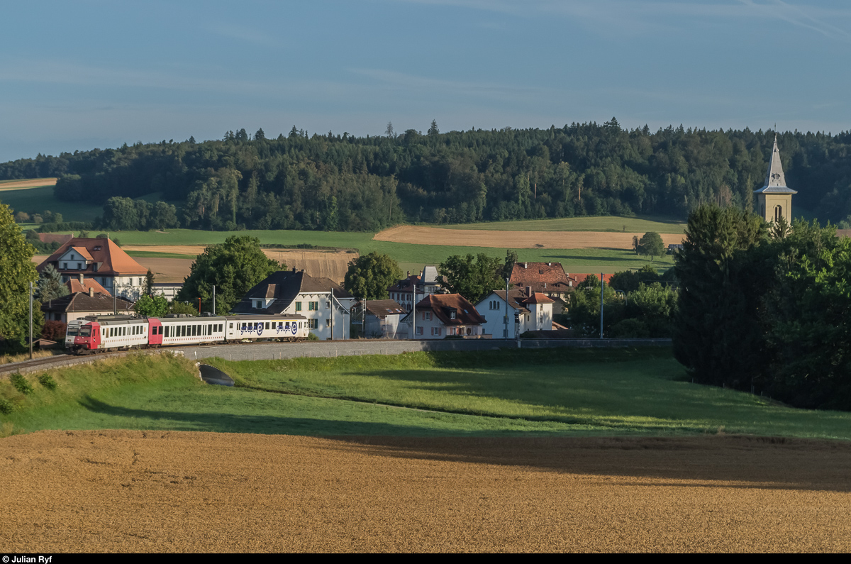Am 4. August 2016 unternahm ich einen weiteren Anlauf, die TPF RBDe 567 zu Fotografieren, nachdem ich beim ersten Mal etwas Wolkenpech hatte. Aus verschiedenen Gründen wählte ich dafür wieder die selben Stellen in Belfaux. Hier fährt der RBDe 567 182 mit Bt 383 in Werbelackierung als S21 in Richtung Fribourg. Die Fahrzeuge mit runder und eckiger Front sind technisch identisch und werden auch in den selben Zügen eingesetzt. 