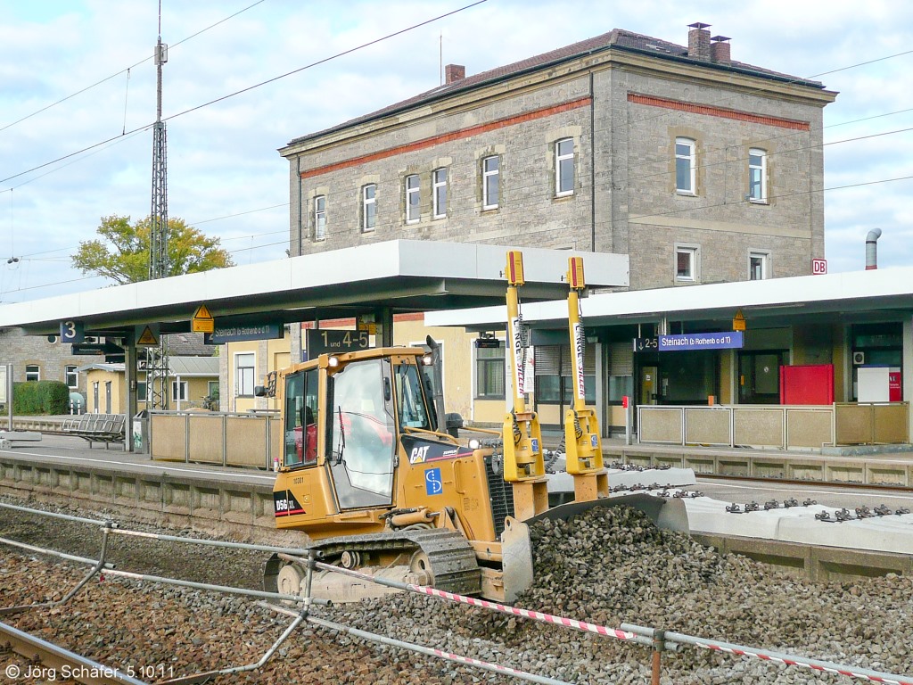 Am 5.10.11 wurde im Bahnhof Steinach das Planum von Gleis 3 erneuert. Statt den Zügen von Würzburg nach Ansbach machten sich dort Baumaschinen breit. Die Raupe schob am Abend bereits neuen Schotter in das Gleisbett.