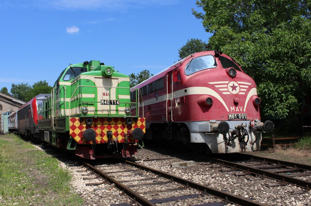 Am 5.6.2022 stehen die M40.114 und die M61.001 (beide von MÁV Nosztalgia) nebeneinander im Bahnhistorische Park Budapest und warten auf ihre nächsten Sonderzugeinsätze.
Beide Triebfahrzeuge besitzen die Ursprungslackierung ihrer Auslieferung.