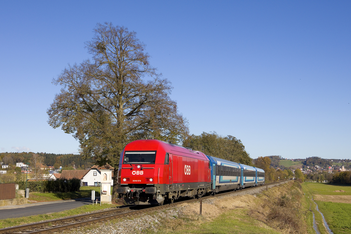 Am 6. November 2023 war 2016 078 mit dem IC 312 (Tatabánya - Graz Hbf) unterwegs. Hier ist der Zug bei Laßnitzthal zu sehen. Rechts im Hintergrund ist die Stadt Gleisdorf zu erahnen. 