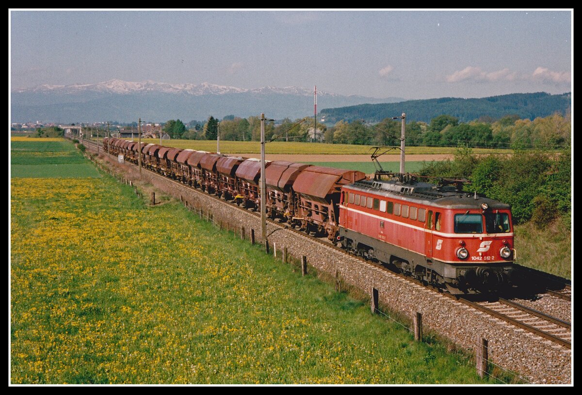 Am 7.05.2002 fährt 1042 512 mit einem Güterzug zwischen Knittelfeld und Fentsch St.Lorenzen durch die blühenden Wiesen des Aichfeldes. Im Hintergrund , noch mit Schneeresten bedeckt,sieht man die Seetaler Alpe mit ihrem höchsten Gipfel dem Zirbitzkogel (2396m).