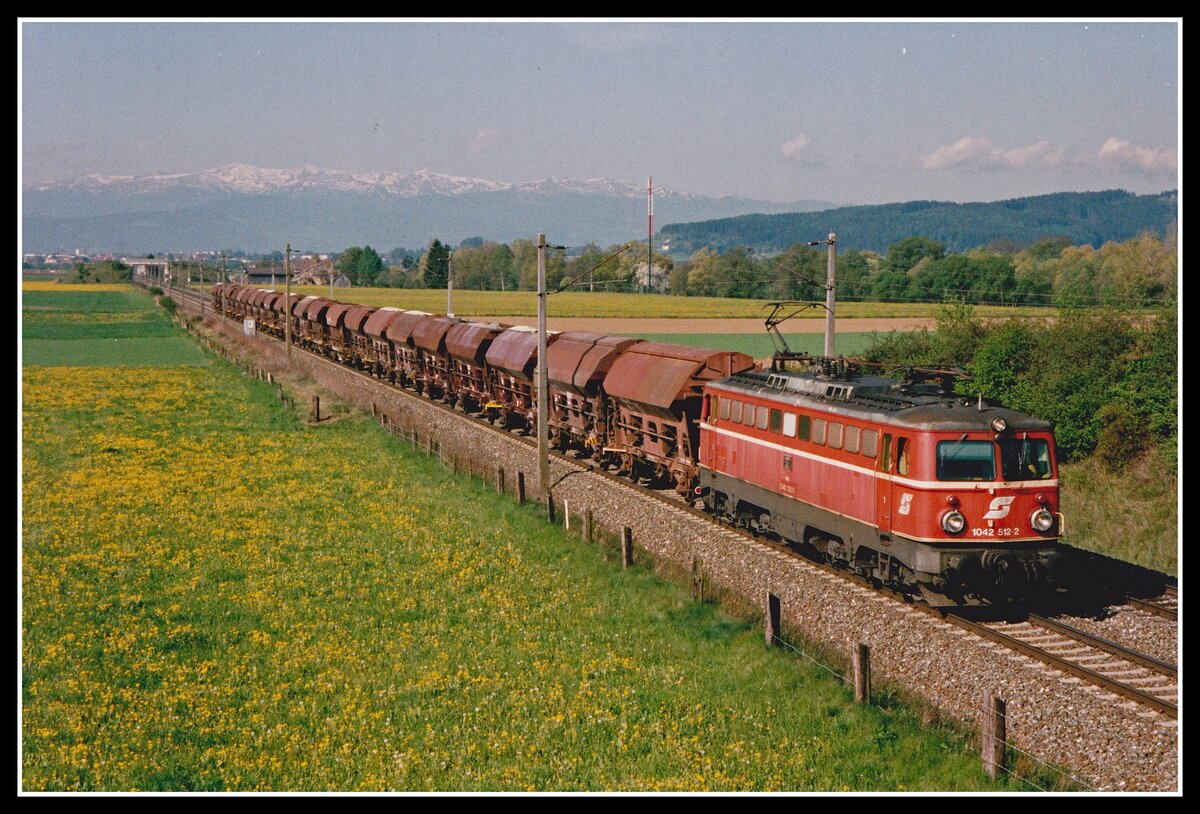 Am 7.05.2002 fährt 1042 512 mit einem Güterzug zwischen Knittelfeld und Fentsch St.Lorenzen durch die blühenden Wiesen des Aichfeldes. Im Hintergrund , noch mit Schneeresten bedeckt,sieht man die Seetaler Alpe mit ihrem höchsten Gipfel dem Zirbitzkogel (2396m).