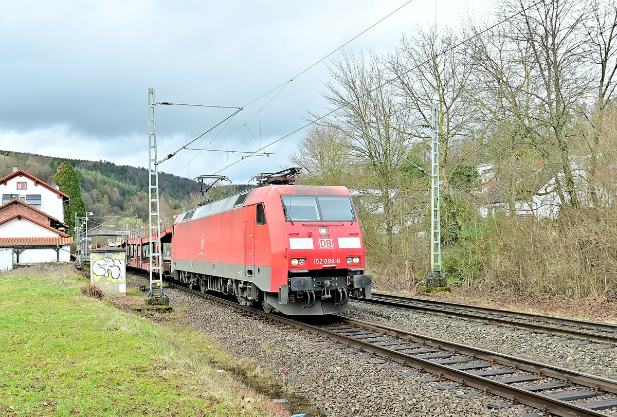 Am 9.3.2023 ist die 152 099-8 mit einem leeren Autotransportwagenzug durch Neckargerach nach Bad Friedrichshall Hbf fahrend vor meine Optik geraten.