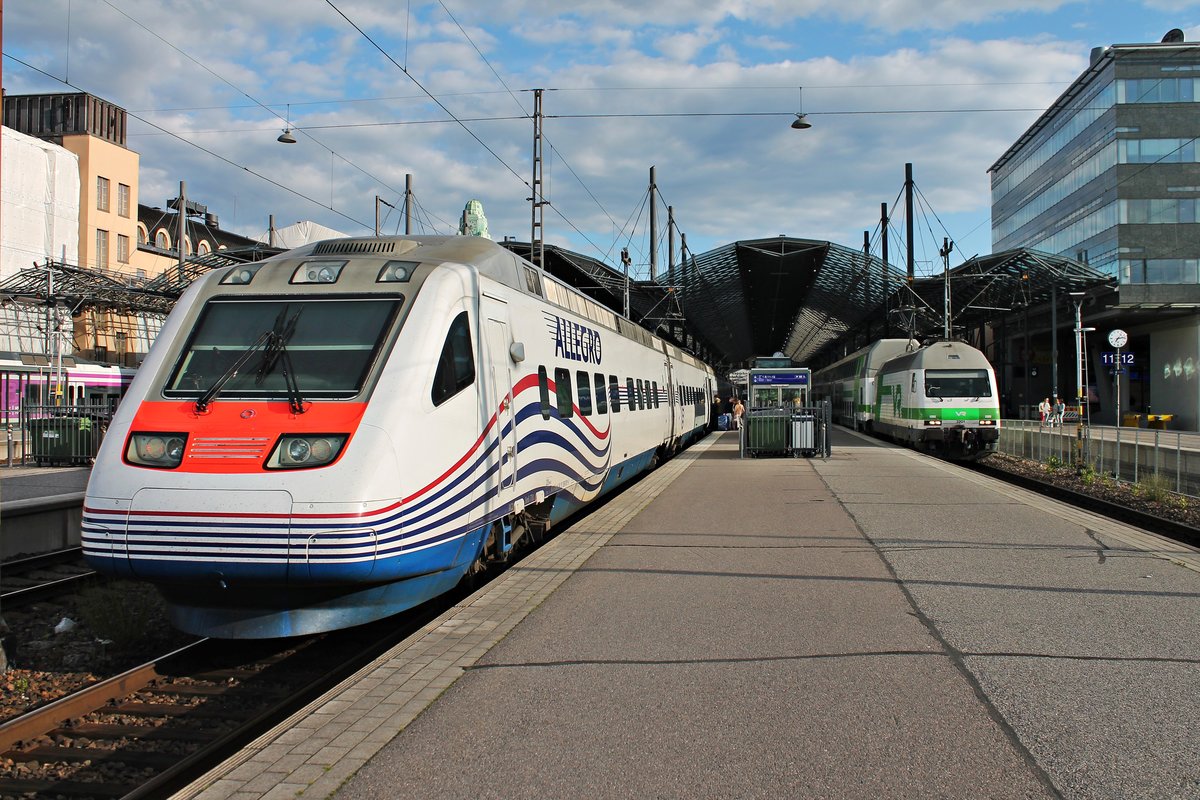 Am Abend des 12.07.2019 stand Sm6 7751 (3 890 001-0) als AE 778 (Helsinki - St. Petersburg) auf Gleis 9 im Starbahnhof und wartete auf ihre Ausfahrt in Richtung Russland. Links ist Sr2 3201 mit IC 73 (Helsinki - Kuopio), welche ebenfalls auf Ausfahrt wartete.