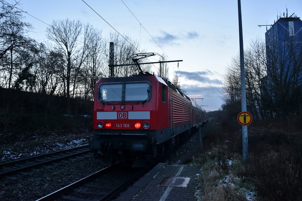 Am Abend des 12.2.2018 schiebt die 143 168 einen RB 27 Dostock gen Mönchengladbach Hbf aus Jüchen hinaus.