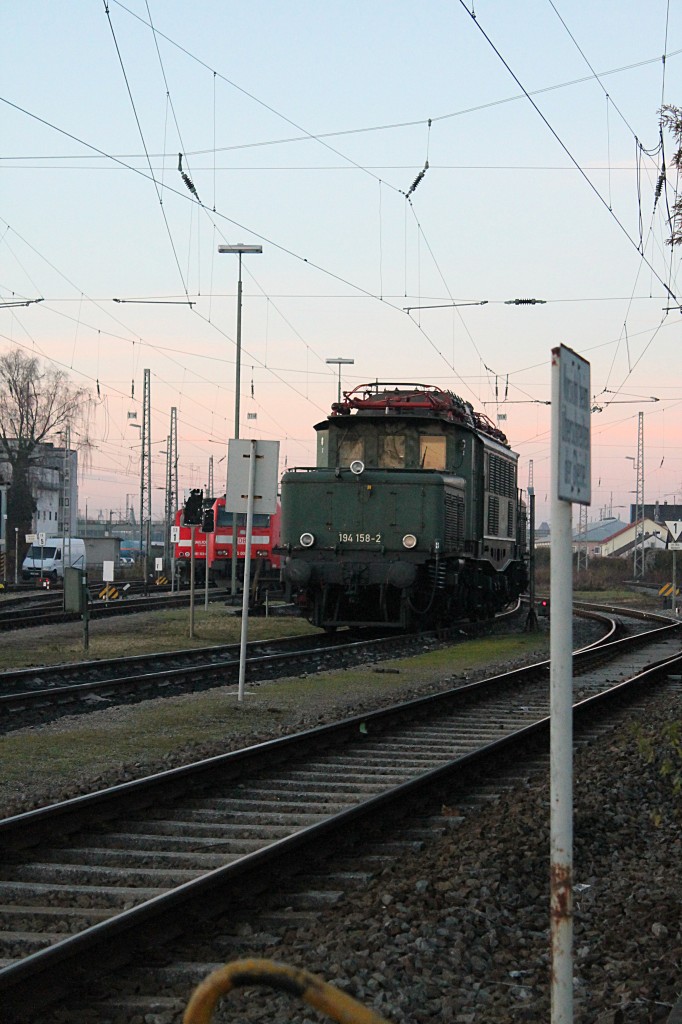 Am Abend des 16.12.2013 steht 194 158 im letzten Abendlicht abgebügelt im BW Ingolstadt. Von der Straße aus kann man gerade noch ins BW fotografieren, darum ist das Krokodil auch so zwischen den Schildern plaziert.