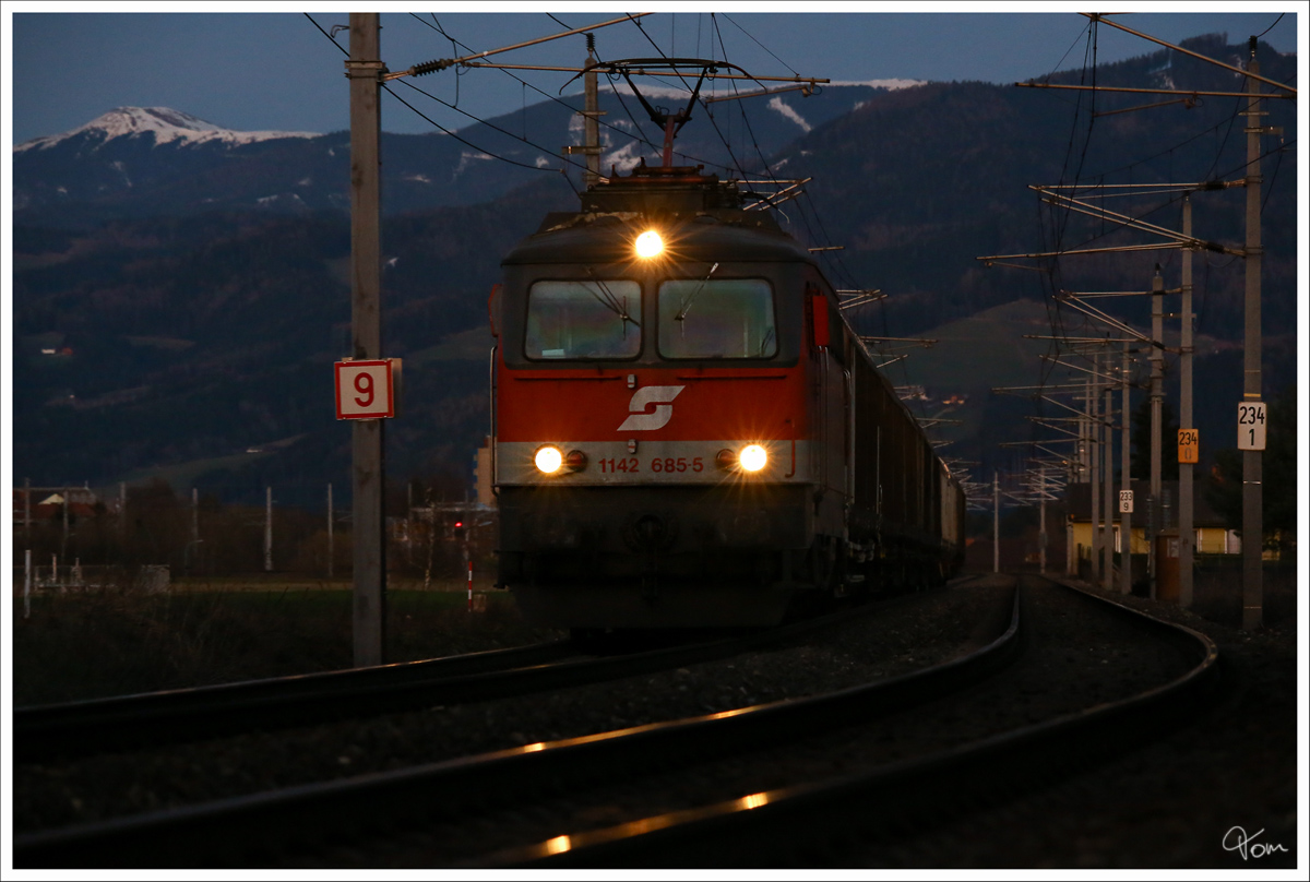 Am Abend des 17.3.2014, fährt die 1142 685 mit einem Güterzug durch Zeltweg. 