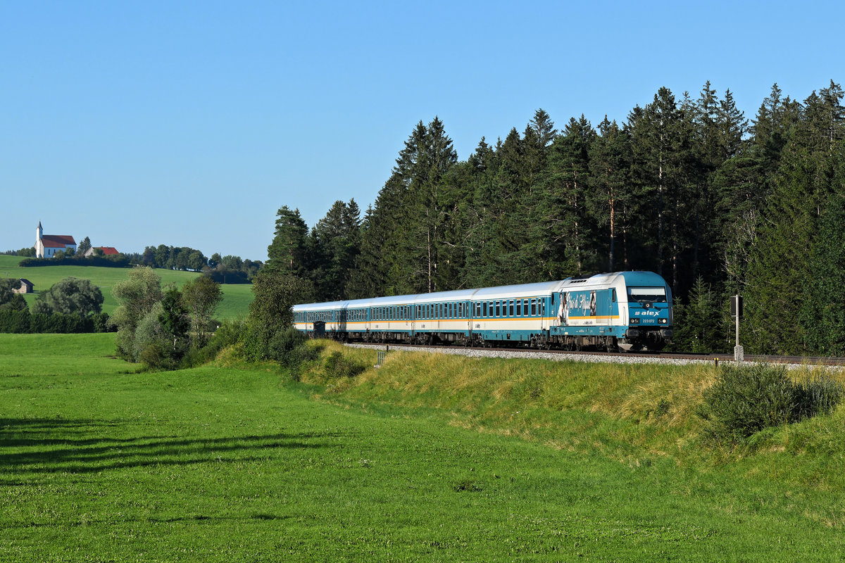 Am Abend des 30. Juli 2020 konnte ich den von der 223 072 geführten ALX 84114 auf seiner Fahrt nach Hergatz bei Görwangs im Ostallgäu aufnehmen. Im Hintergrund ist die Wallfahrtskirche von St. Alban zu erkennen. 