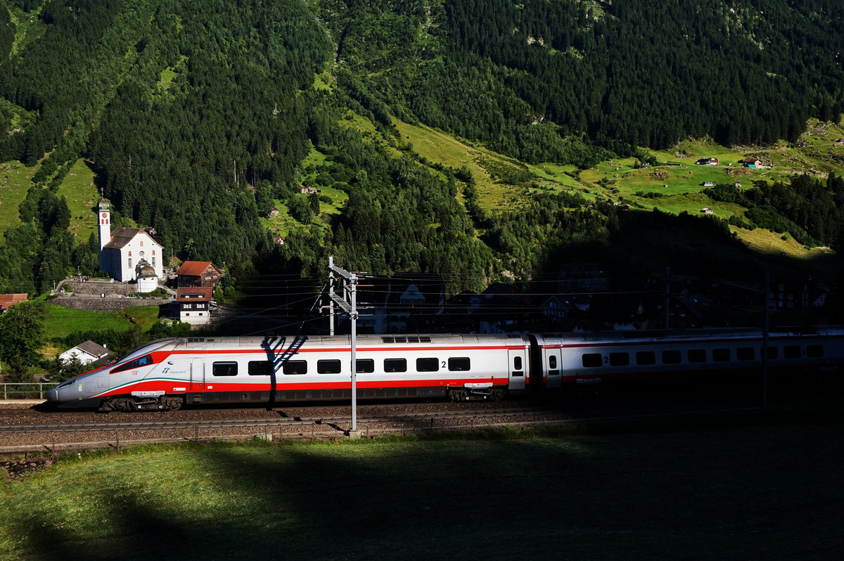 Am Abend verschwindet ein ETR 610 der FS, oberhalb von Wassen, aus den letzten Sonnenstrahlen im finstern Schatten.
Aufgenommen am 19.7.2016.