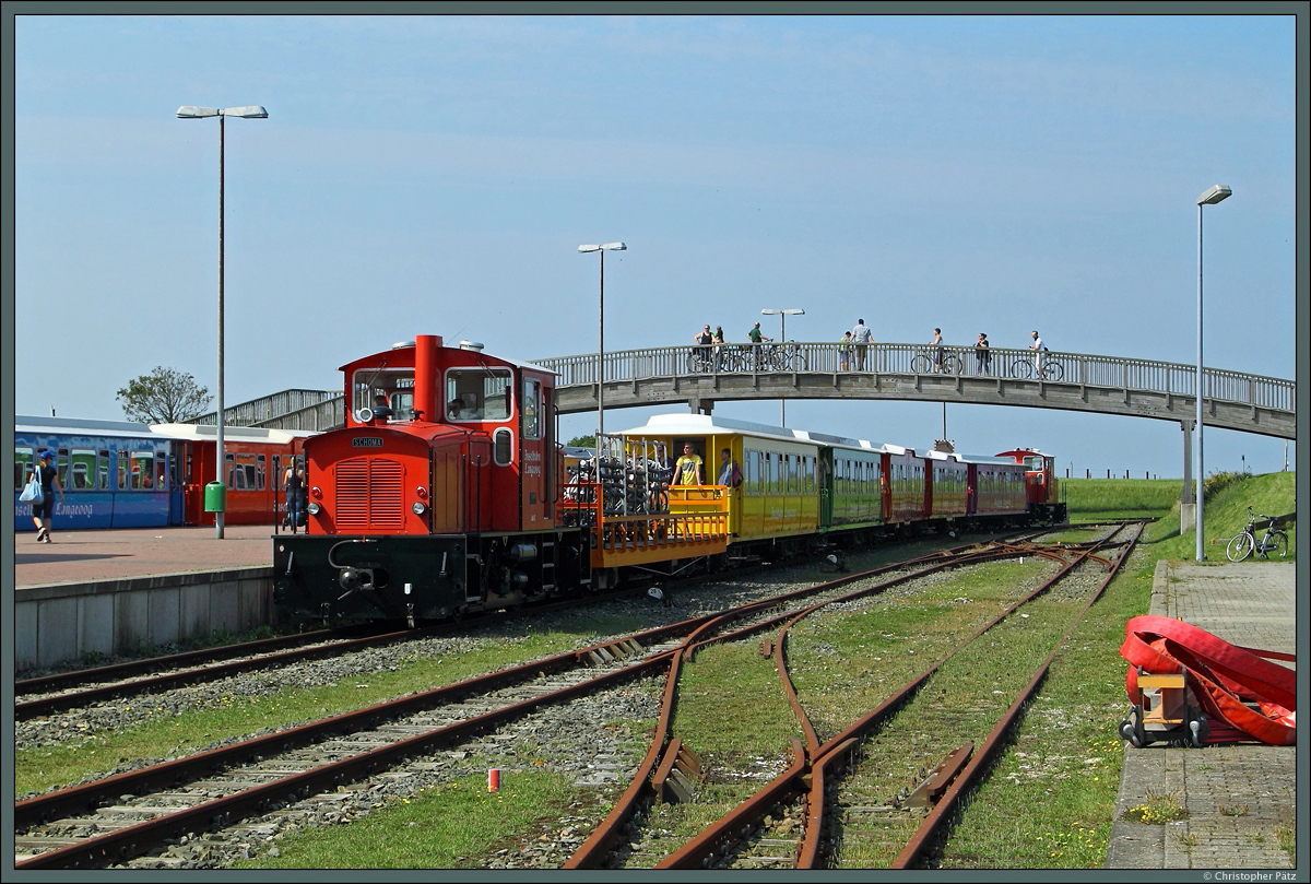 Am Anleger der Fähre nach Bensersiel steht Lok 2 der Inselbahn Langeoog mit einem Zug zum Bahnhof Langeoog bereit und erwartet die zahlreichen Fahrgäste. (21.08.2015)