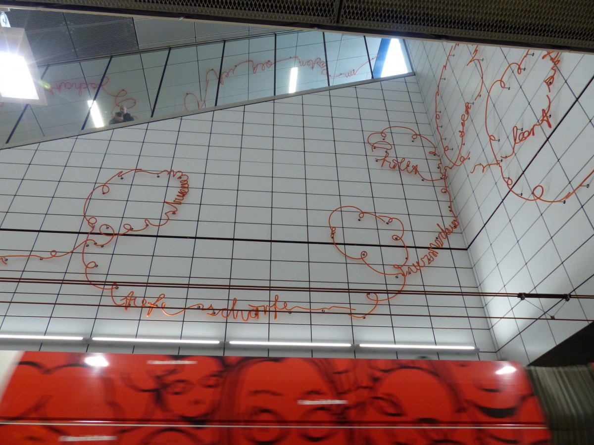 Am Bahnhof Kirchplatz ist eine orange Linie zu Buchstaben verbunden, das Kunstwerk von Enne Haehnle nennt sich  Spur X . Unweigerlich versucht man, den Text zu entziffern, was nur bedingt gelingt - und was auch nicht gewollt ist. Vielmehr wird zu einem Nachdenken über Schrift angeregt. 21.2.2016, Düsseldorf