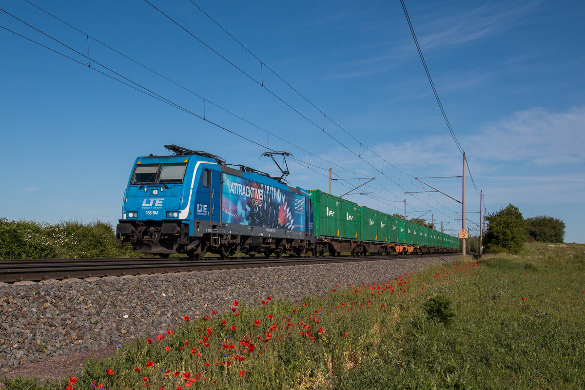 Am blühenden Mohn vorbei zieht 186 941-1 der LTE einen Containerzug in Richtung Magdeburg. Fotografiert am 03.06.2023 in Niederndodeleben an der KBS 310.