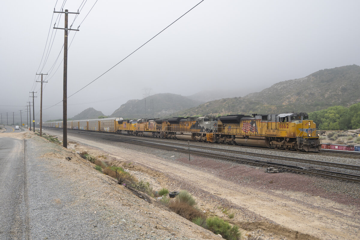 Am Cajon Pass den 26.06.2026 k�mpfte sich der Zug gezogen von Union Paciffic, inRichtung Bastrow in Kalifornien. Durch Zufall erblickte eine Lok an zweiter Stelle, mit Rio Grande Aufschrift und Bemalung. Links im Bild beim wei�en Fahrzeug befindet sich die Route 66 nach Los Angeles bzw. Chicago. 