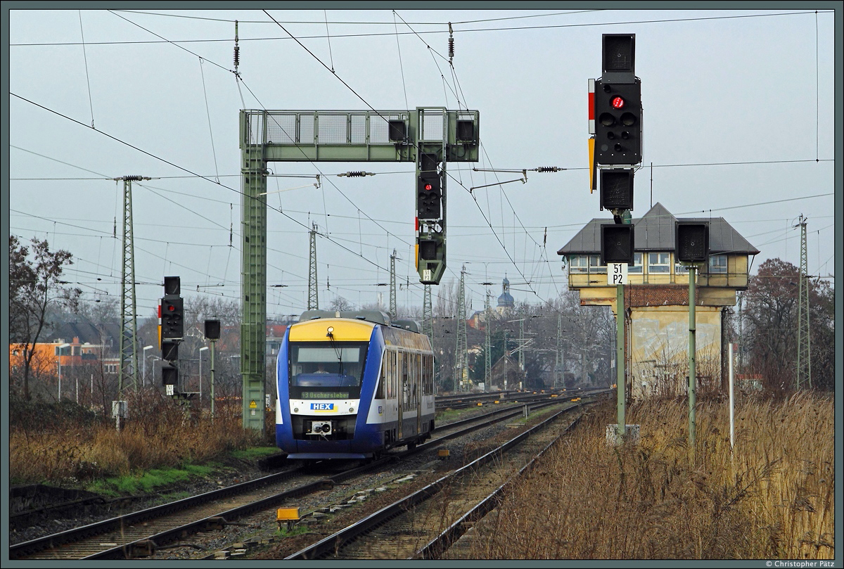 Am diesigen 06.01.2015 erreicht der VT 870 der Verolia-Tochter HarzElbeExpress wenige Minuten nach der Abfahrt in Magdeburg Hbf den Bahnhof Magdeburg-Buckau. Der Zug ist als HEX 80188 auf dem Weg nach Oschersleben. Rechts im Hintergrund ist das 2004 außer Betrieb genommene Stellwerk Bnf erkennbar. 