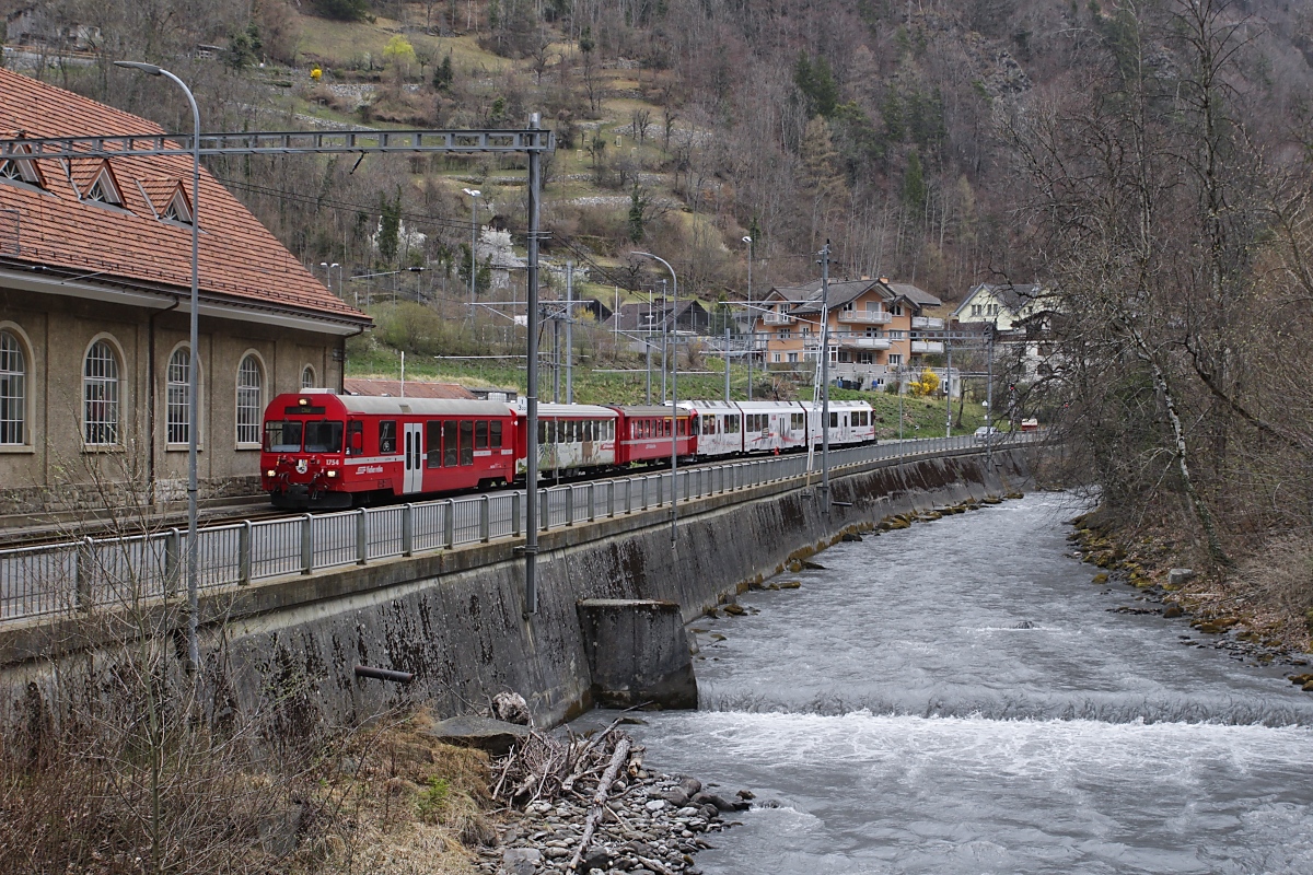 Am ehemaligen Depot Sand vorbei fährt ein Zug der Arosabahn, geschoben vom ABe 8/12 3512, am 31.03.2022 in Richtung Bahnhof Chur