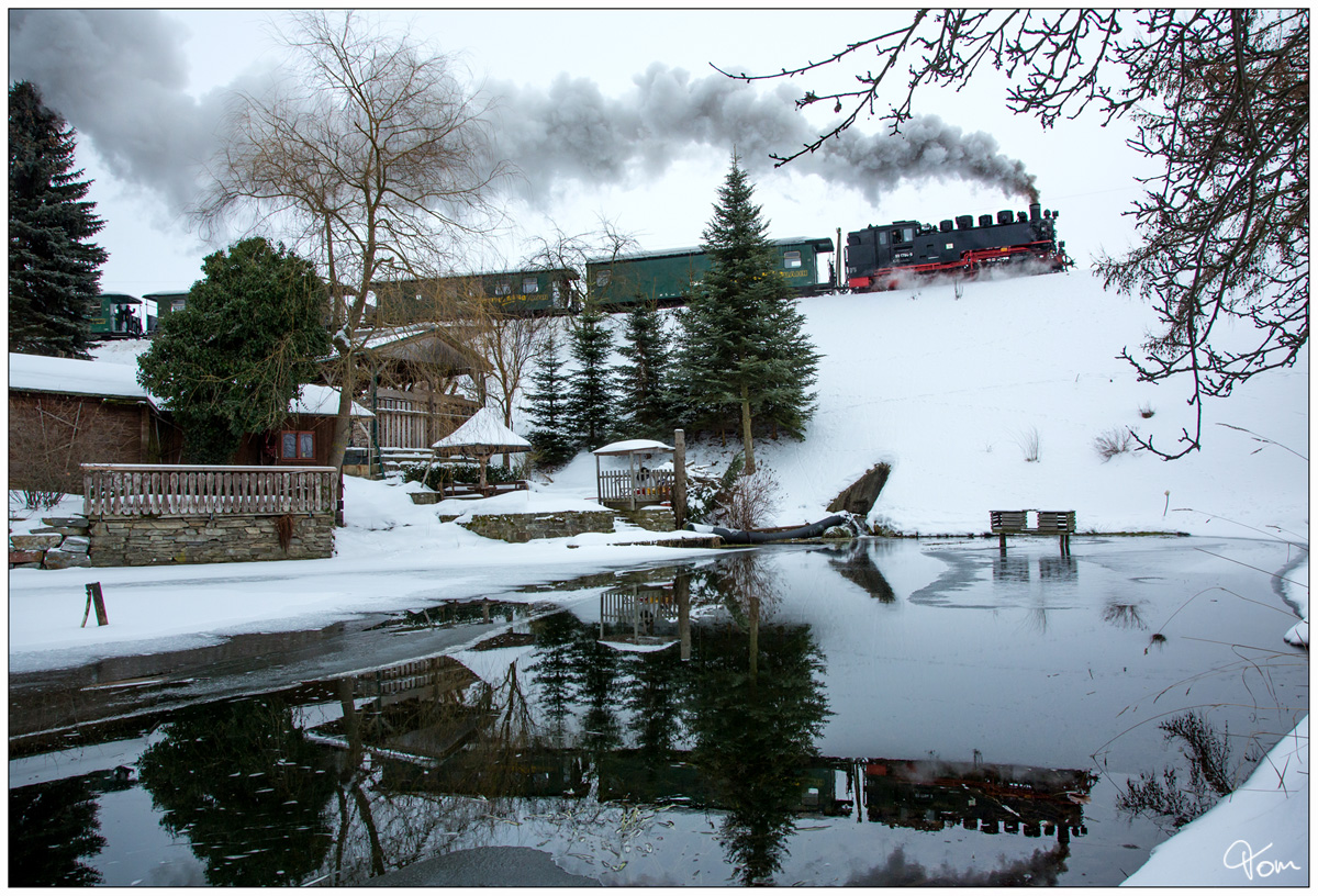 Am Fischteich nahe Cranzahl vorbei, dampft 99 1794 der Fichtelbergbahn von Cranzahl nach Kurort Oberwiesenthal. Leider hatte ich nur das 24mm Objektiv auf der Kamera, sodass ich Kompromisse beim Schnitt eingehen musste.  
01.02.2019