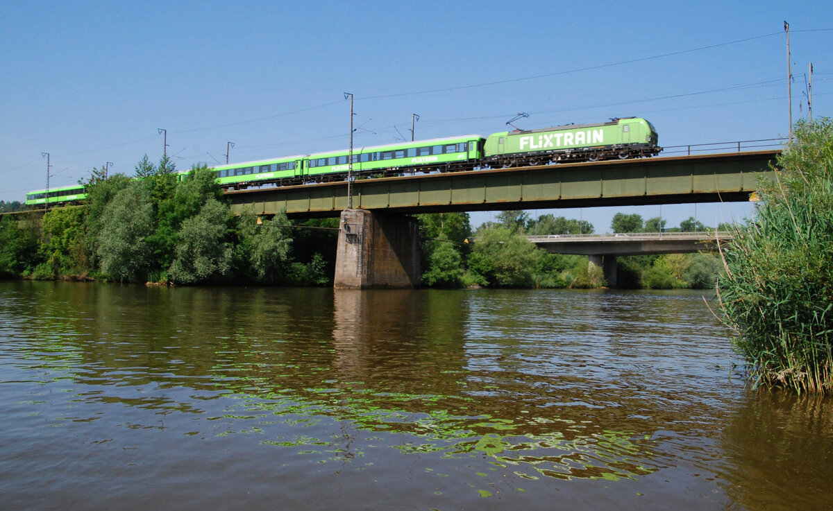Am Freitag, 18.06.2021, war die Betriebsaufnahme der Flixtrain-Linie FLX25 München - Frankfurt/Main und zurück. Die Aufnahme zeigt den FLX76330 einen Tag später am Samstagmorgen ca. 20 min verspätet mit Lok 193 604 und vier bei Talbot in Aachen modernisierten ex-Interregiowagen auf der Mainbrücke zwischen Heidingsfeld und Würzburg nordwärts fahren. Die IGE ist Betreiberin des Zugpaares und lässt es planmäßig montags, donnerstags, freitags, samstags sowie sonntags zwei Mal durch Würzburg verkehren.

