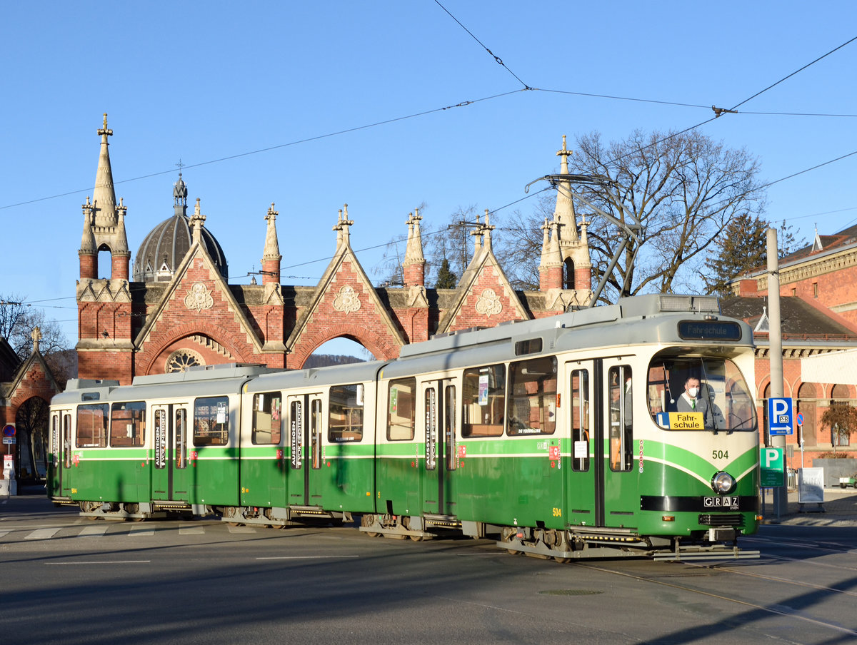 Am frühen morgen des 14. Feber 2021 war der HGL Triebwagen 504 als Fahrschule unterwegs, und wurde von mir vor dem Haupteingang des Grazer Zentralfriedhofs fotografiert. Die Schleife am Zentralfriedhof wird planmäßig nicht mehr befahren, nur noch für Sonderfahrten, Probefahrten oder Fahrschulfahrten.
Die Kirche im Hintergrund  ist den Slawenaposteln Kyrill und Metho gewidmet und wurde im Jahr 1895 fertiggestellt, Architekt war Carl Lauzil.