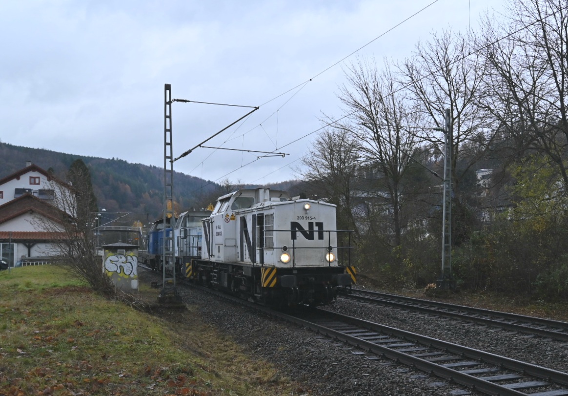 Am frühen Nachmittag des 27.11.2021 kommt durch Neckargerach ein Lokzug der aus der 203 915, der 0276 003 und der 212 279 besteht gen Binau fahrend vor mein Objektiv gefahren. 